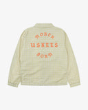 Back view flat shot of Uskees pastel yellow check coach jacket for men showing the North Born Uskees lettering presented on a white background.