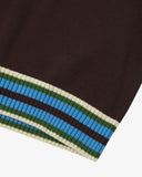 Close-up of an Uskees brown men's tank top with a striped hem featuring blue, green, and beige colors.