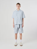 Male model wearing an Uskees light blue shirt and shorts outfit presented on a white background