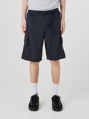 Bottom half of male model wearing Uskees black trek shorts showing the pockets, Presented on a light gray background