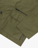 Close-up of an Uskees ivy green ripstop jacket with a pocket and zipper on a white background