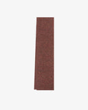 Flat shot of an Uskees brick red unisex ribbed wool scarf presented on a white background 