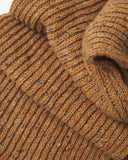 Close up shot of a butterscotch brown knitted Uskees ribbed wool scarf showing the speckled colours.