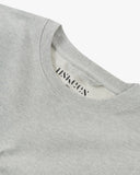 Front, flat , close up shot of Uskees grey marl Champ Sweatshirt for men showing the neckline and printed branding. Presented on a white background.