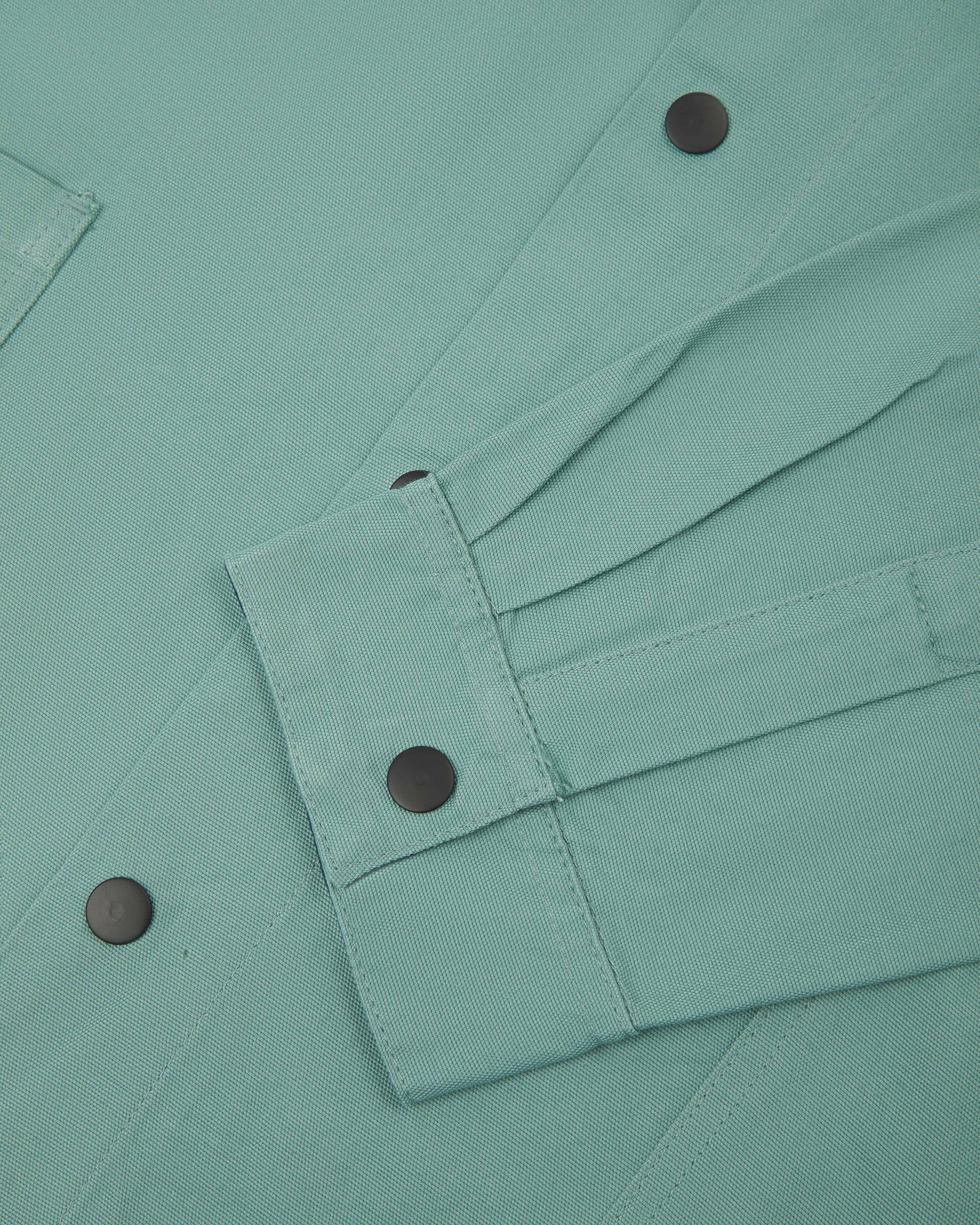 Close up view of Uskees eucalyptus organic cotton coach jacket showing sleeve and front popper fastenings 