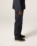 Side view of  male model wearing Uskees raw orta denim workwear pants in dark indigo with matching overshirt.
