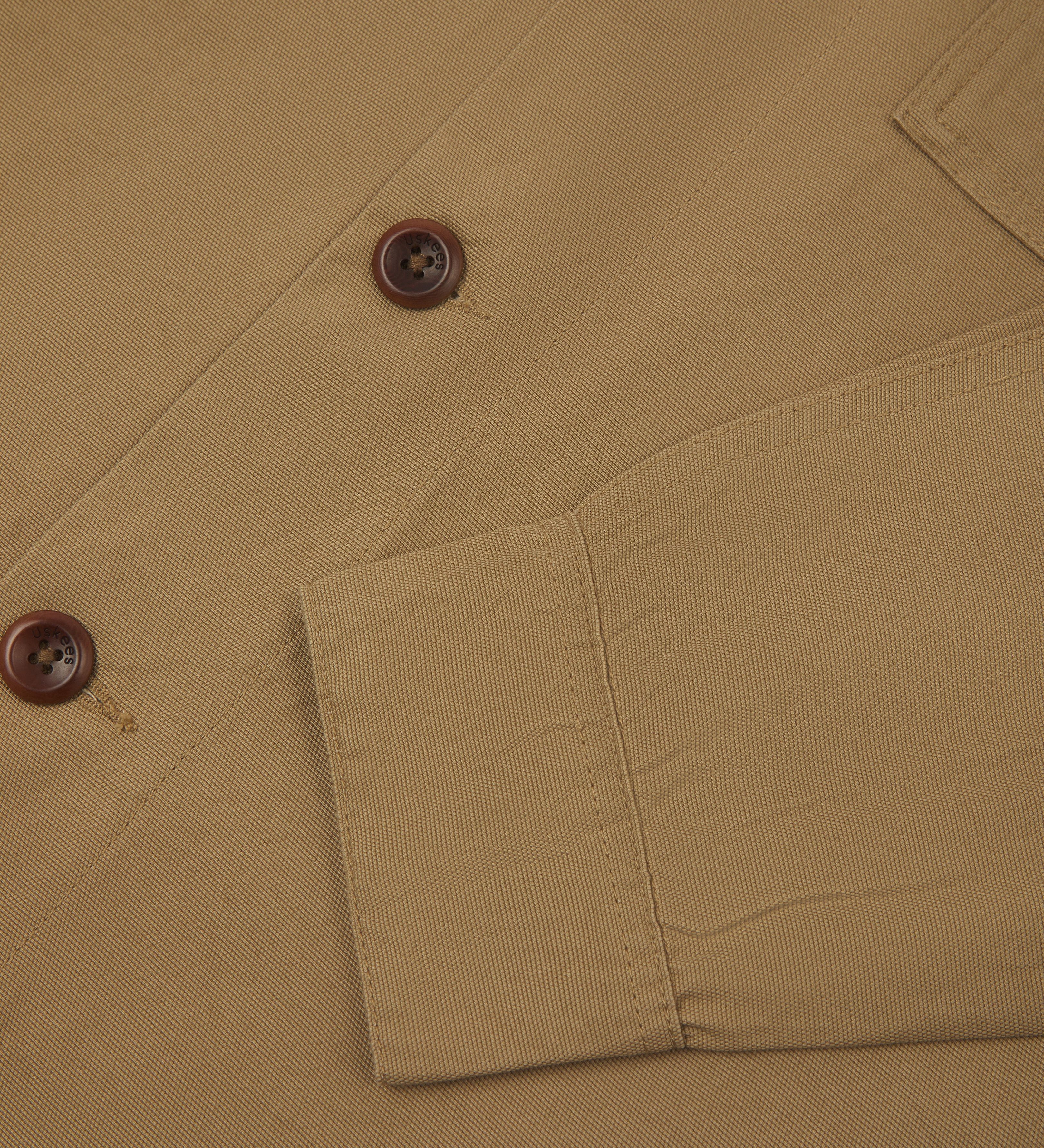 Close-up view of khaki buttoned 3003 workshirt for men from Uskees, showing sleeve and corozo button detail.