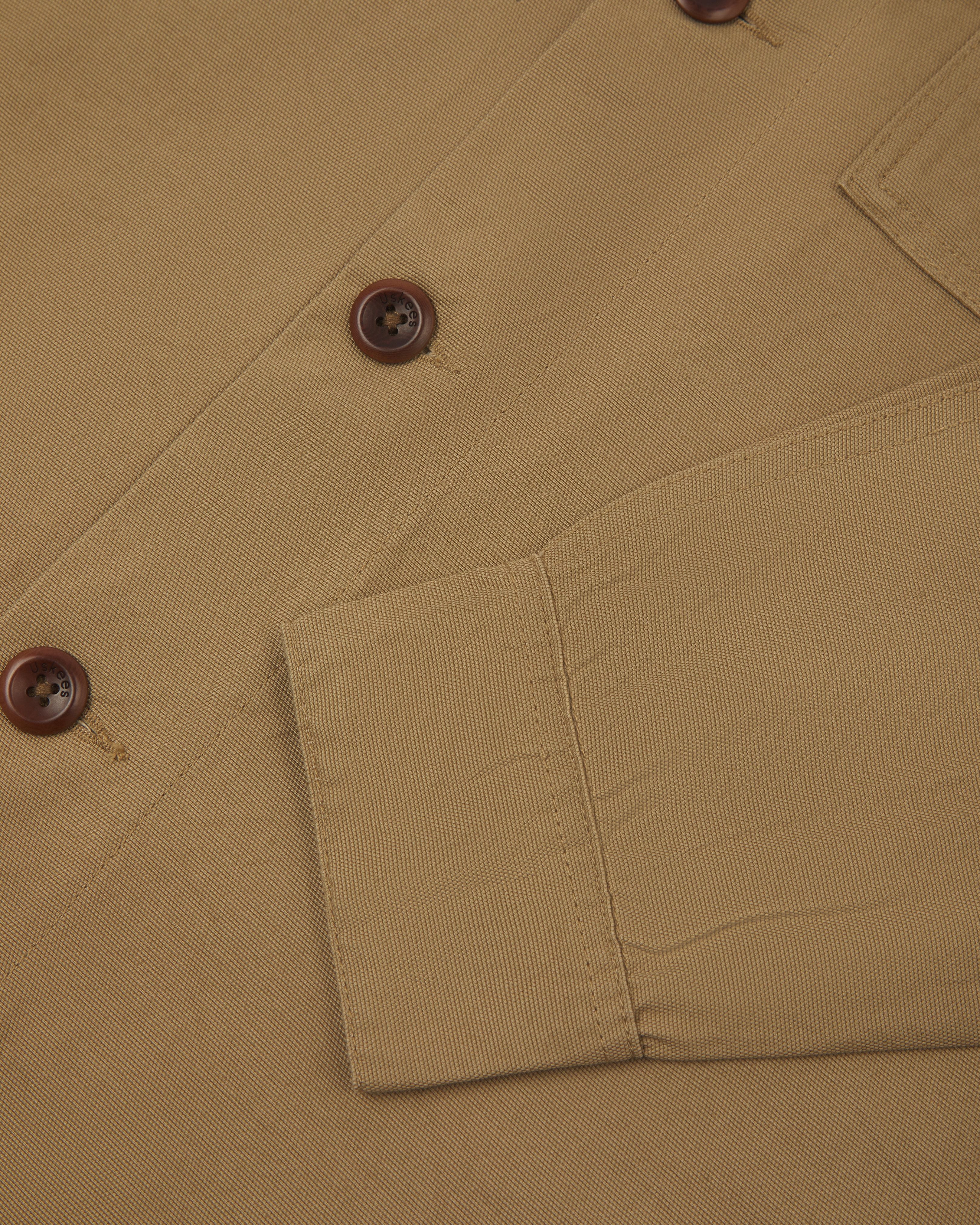 Close-up view of khaki buttoned 3003 workshirt for men from Uskees, showing sleeve and corozo button detail.