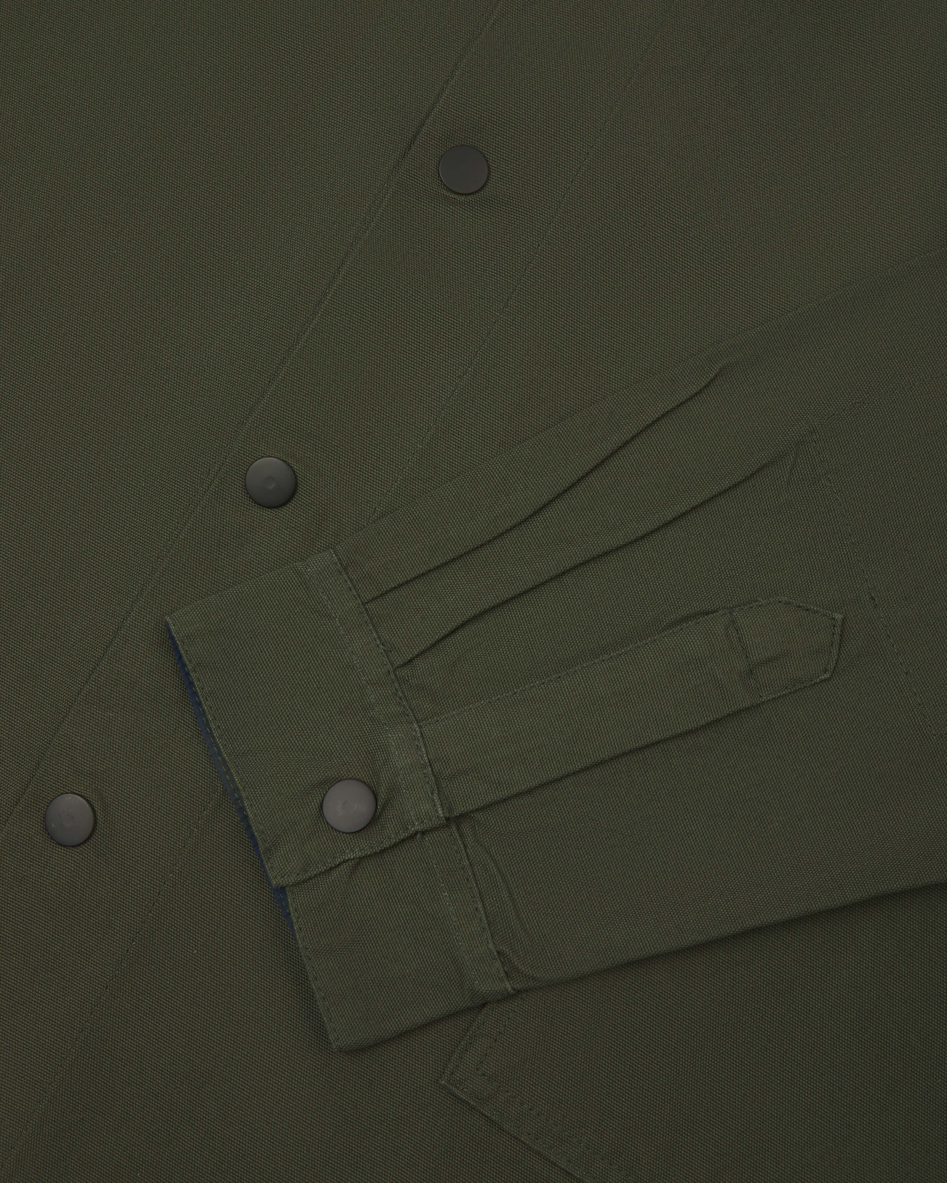 front flat shot of uskees dark green oversized coach jacket with popper fastening, showing cuff detail
