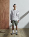 Front view model shot of #3002 light-grey zip front jacket from Uskees. Fully zipped-up and paired with khaki shorts.
