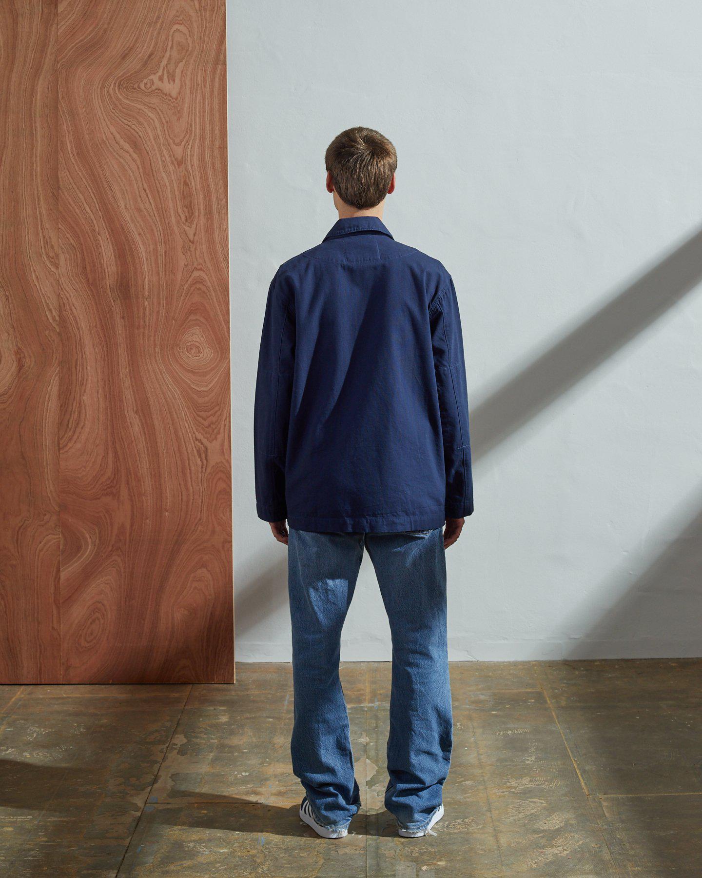 Full-length, rear view of model wearing Uskees #3006 navy-blue blazer showing reinforced elbows and simple design.