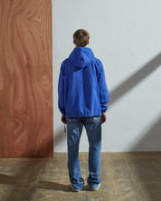 Full-length, rear view of model wearing Uskees ultra blue smock showing reinforced elbows, ribbed cuffs and waist.