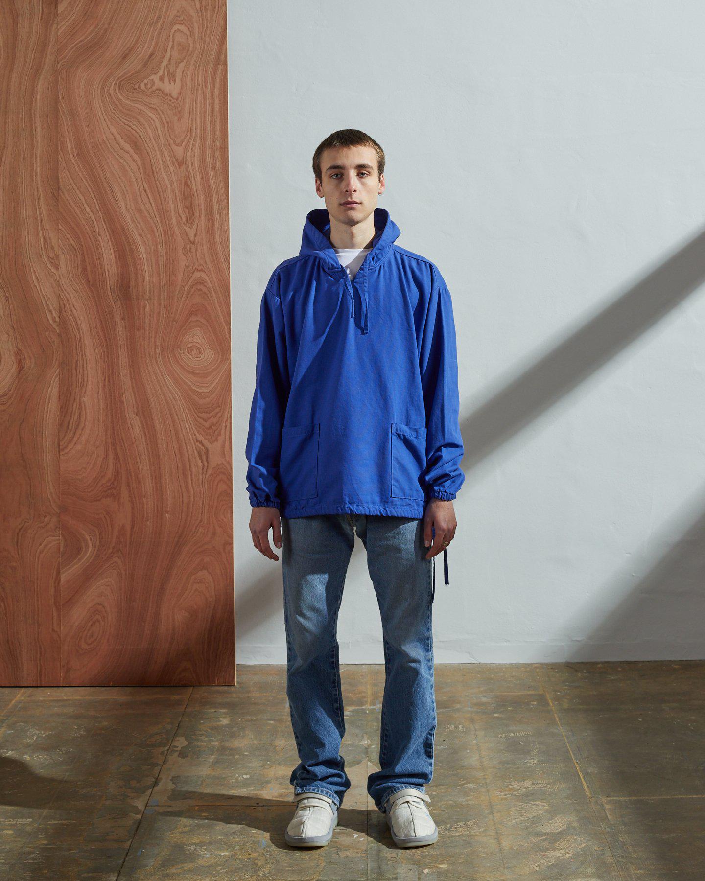 Full-length frontal view of model wearing #3008, bright blue smock paired with blue jeans, demonstrating loose, simple design.