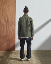 Full-length back model shot of Uskees #3011 vine green overshirt. Paired with grey cargo pants.
