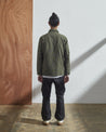 Full-length back model shot of Uskees #3011 vine green overshirt. Paired with grey cargo pants.