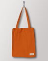 Full front hanging shot of Uskees #4002, small golden-orange tote bag, showing double handles and Uskees woven logo.