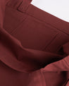 Close-up inside view of Uskees #4002 small tote bag in off-red with focus on the small internal pocket.