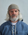 Model wearing Uskees 4005 'light oat' off-white coloured wool hat, paired with blue Uskees smock.